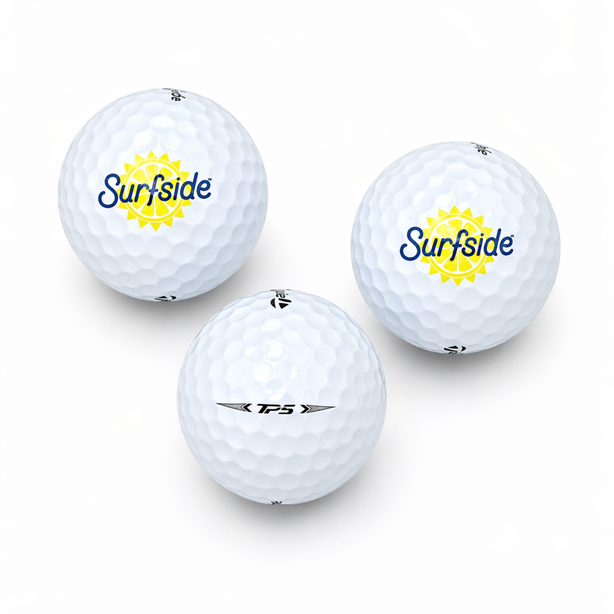 Three golf balls with 'Surfside' branding and TP5 branding on a white background