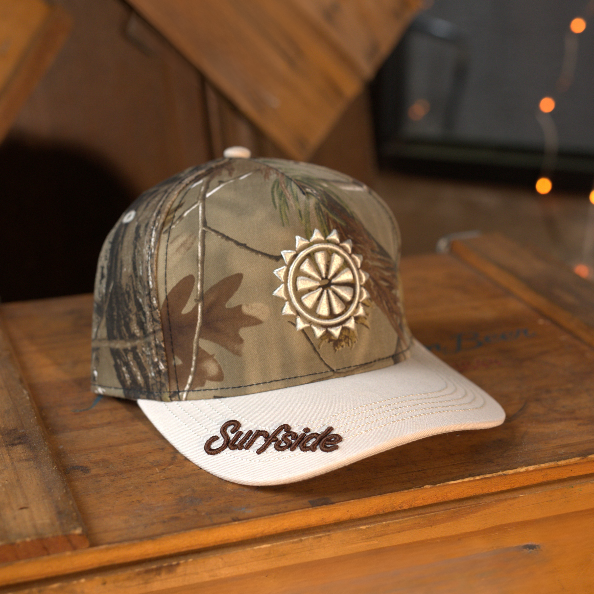 Camo print and cream hat featuring an embroidered sun and Surfside logo on the brim of the snapback
