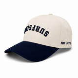 Beige and navy cap with "Surfside" upside down print and No Rivals print on the side laying on a white background