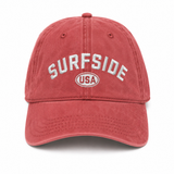 Red dad hat with 'Surfside USA' embroidered sitting on a white background