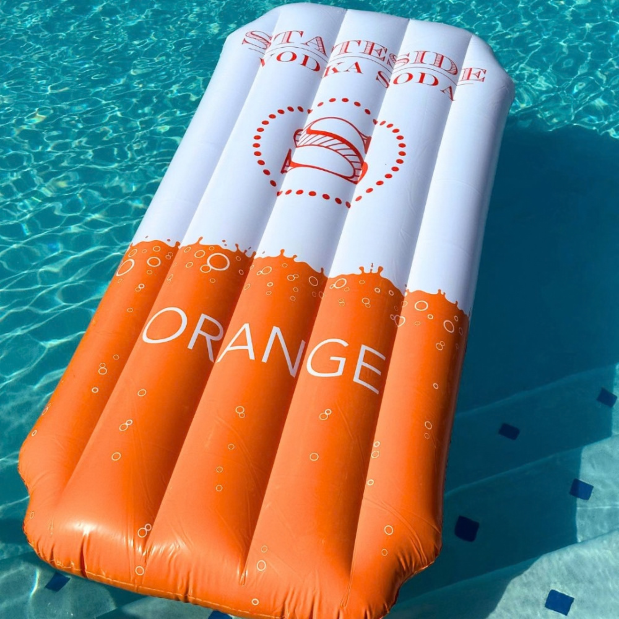 Inflatable pool float with 'Stateside Vodka Soda Orange' branding in a pool