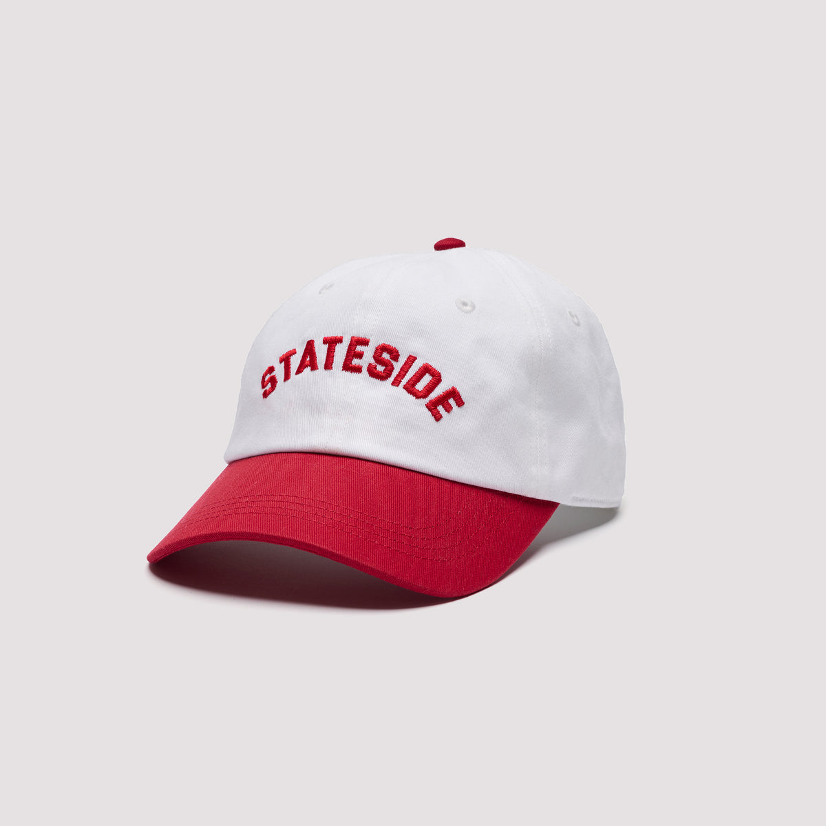 White Stateside baseball cap featuring red embroidered front lettering, a contrasting red curved brim, and a matching red top button.