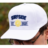 White cap with 'Surfside Est. 2021' text and logo, worn by a person outdoors.