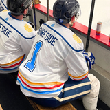 Two hockey players in 'Surfside' jerseys sitting on a bench.