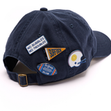 4 pins featured on a navy baseball hat. The pins are tailgate themed with Surfside brand elements
