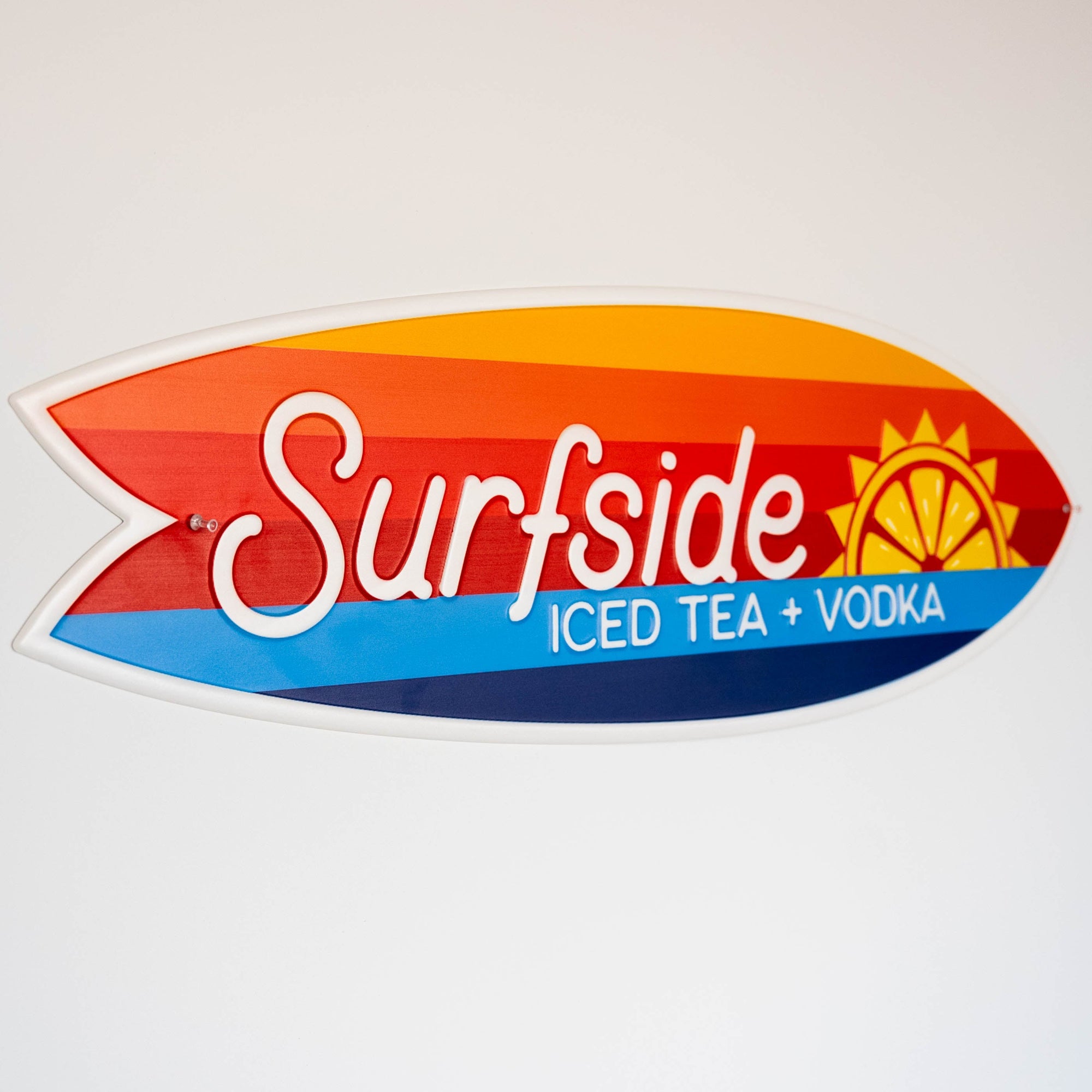 Surfside Iced Tea + Vodka surfboard shaped metal sign on a white background