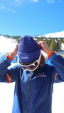 Person wearing the blue Surfside Windbreaker jacket and blue beanie with 'Surfside' branding, standing in a snowy landscape.