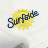 Close up of embroidered 'Surfside' logo on a white sweat shorts 