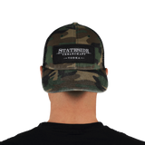 Person facing backwards showing the front of the Stateside Urban Craft Vodka Camo Hat with black patch logo